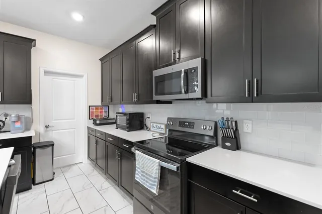 a kitchen with a sink stove and microwave