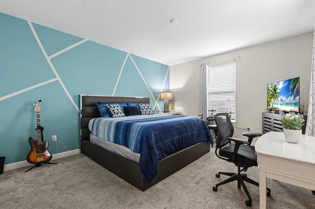 a bedroom with a bed a table and chair