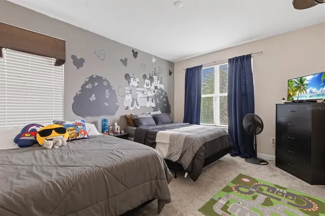 a bedroom with two beds and a potted plant