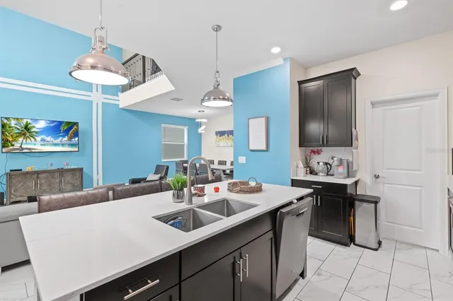 a kitchen with a sink a stove and chairs