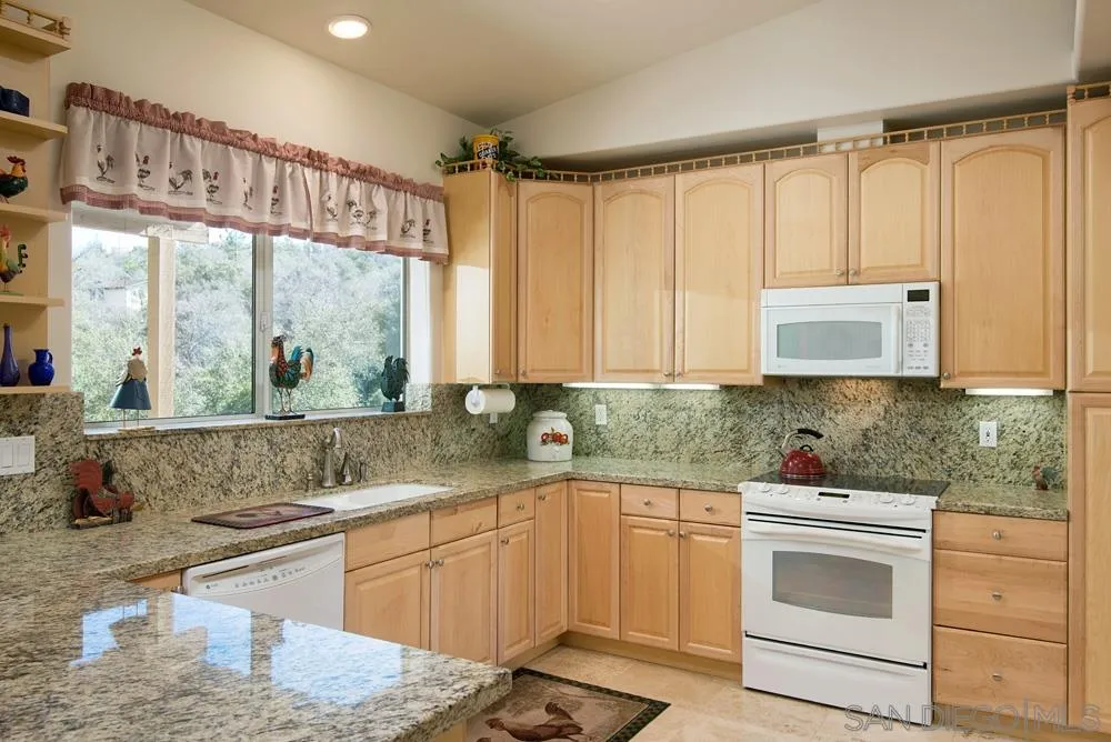 a kitchen with stainless steel appliances white cabinets and a large window