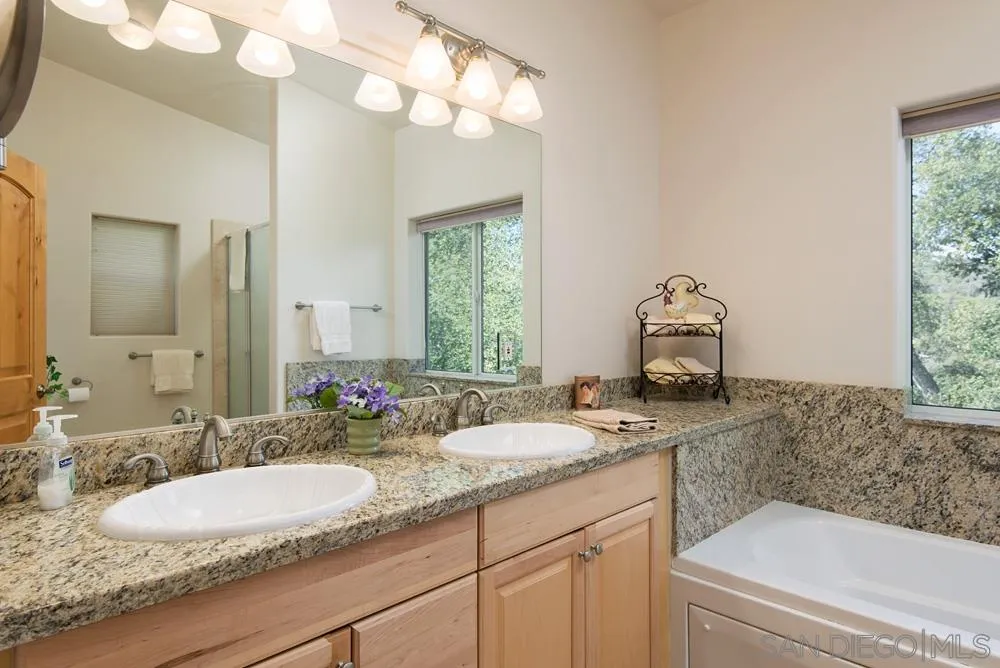 1295 Banner Road Julian, CA 92036 - Photo 19 of 25 a bathroom with a granite countertop sink and a mirror