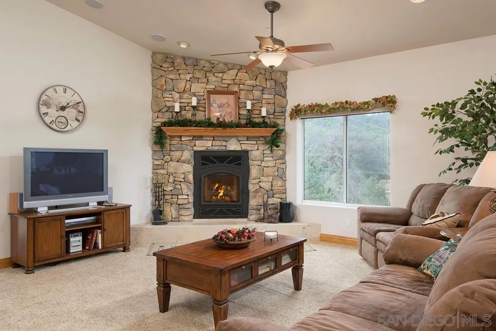 1295 Banner Road Julian, CA 92036 - Photo 9 of 25 a living room with furniture a chandelier and a fireplace