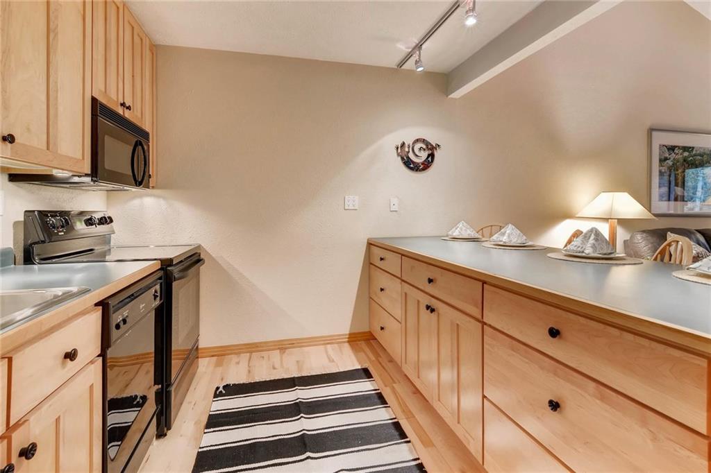 800 Columbine Road, Unit B9 Breckenridge, CO 80424 - Photo 7 of 25 a kitchen with granite countertop white cabinets and white appliances