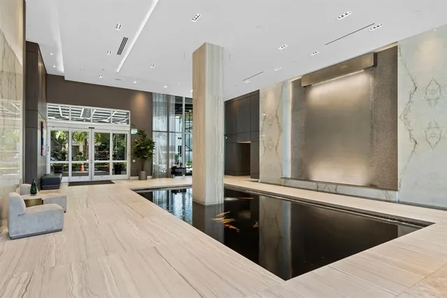 a living room with furniture a lamp and a potted plant