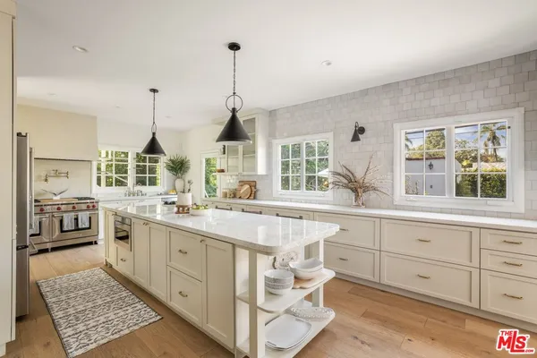 a open kitchen with stainless steel appliances granite countertop a sink a stove and a wooden floors