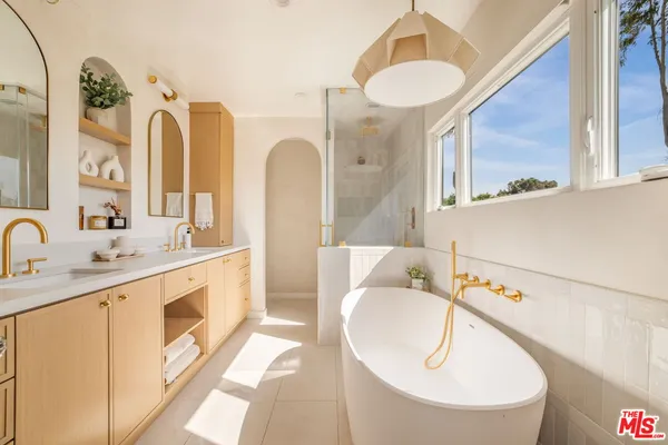 a spacious bathroom with a granite countertop sink mirror and bathtub