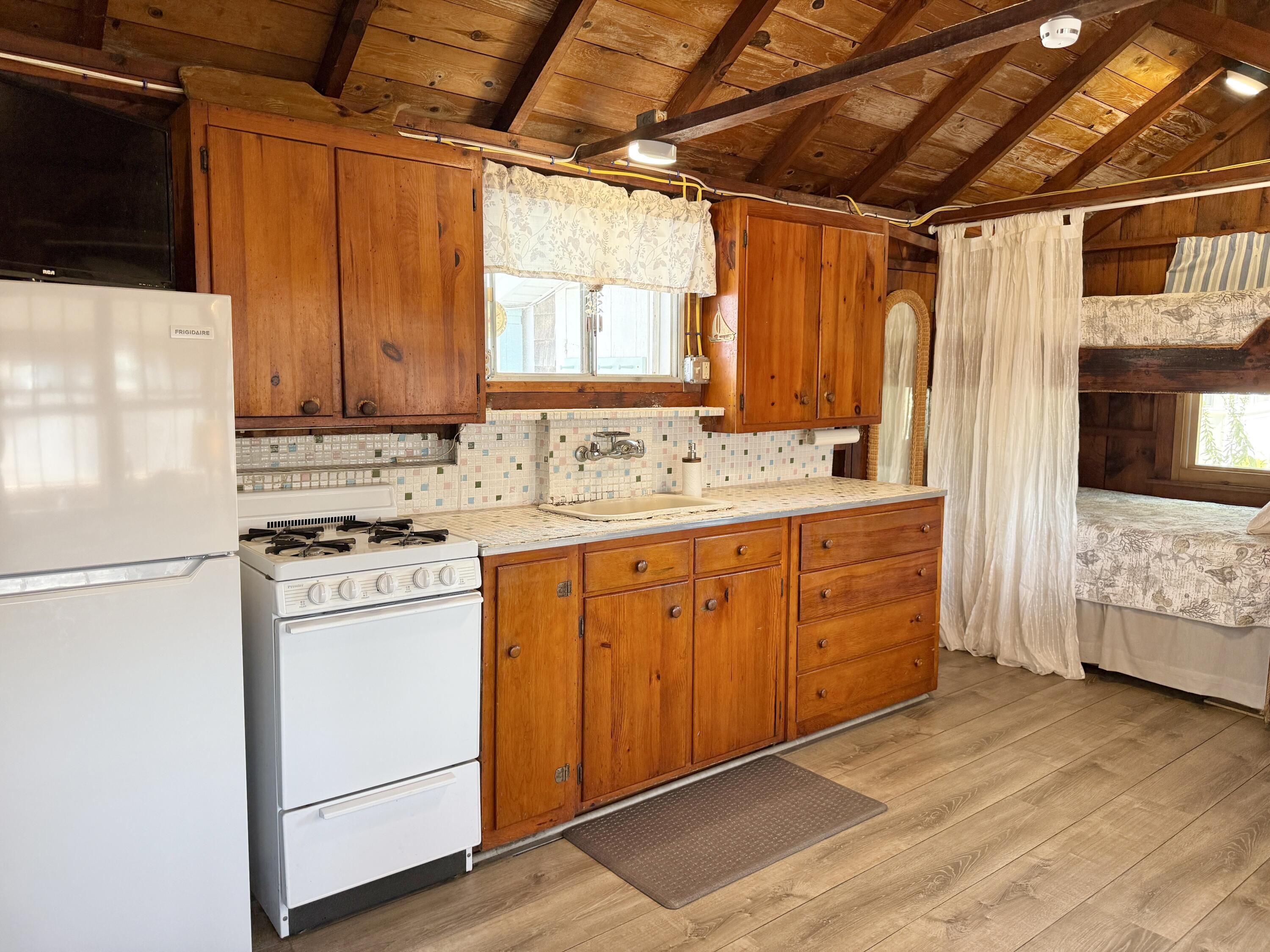 217 Old Wharf Road, Unit 64 Dennis Port, MA 02639 - Photo 18 of 25 a kitchen with stainless steel appliances a stove a sink and a refrigerator
