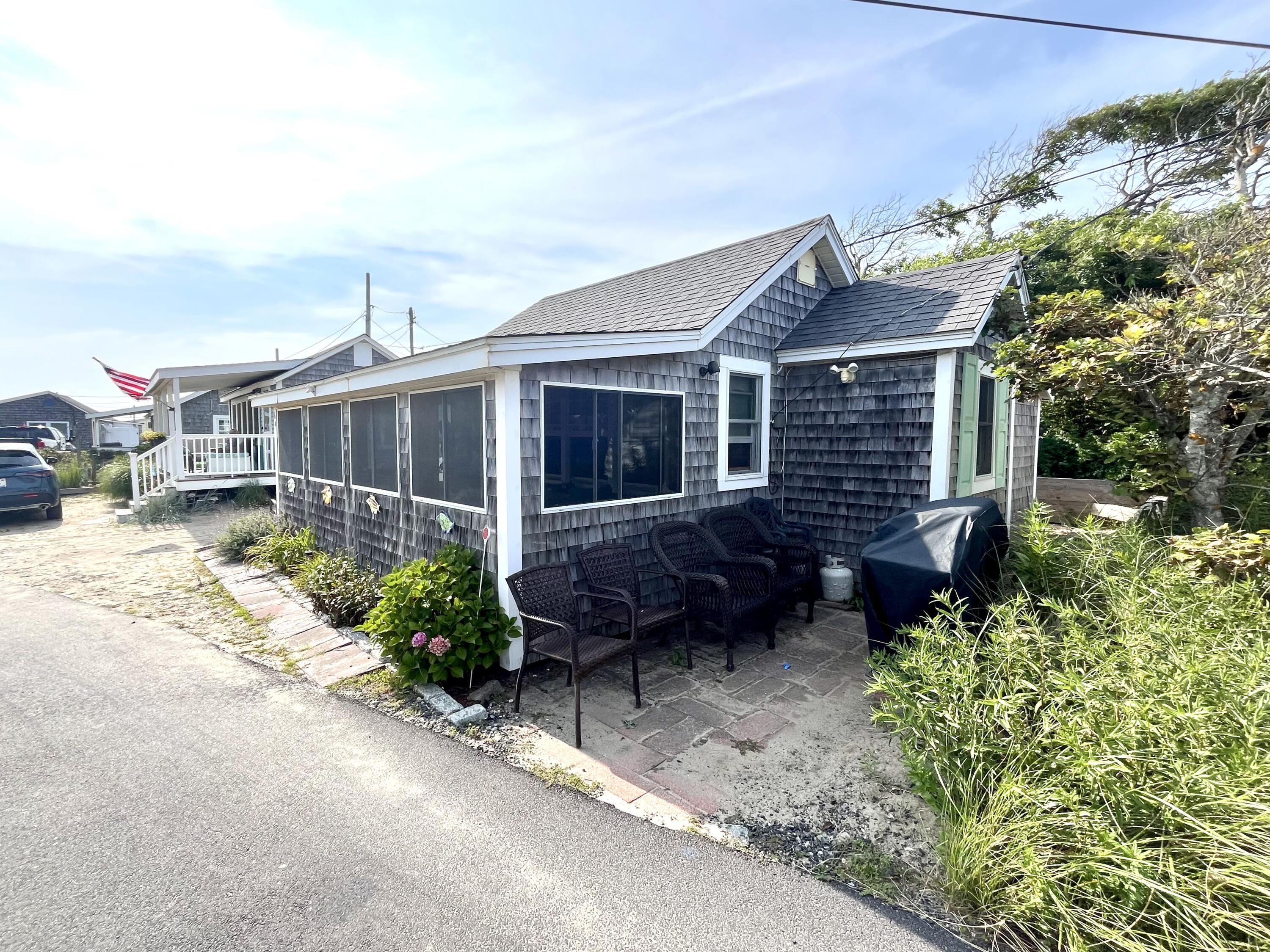 217 Old Wharf Road, Unit 64 Dennis Port, MA 02639 - Photo 3 of 25 a view of a house with a small yard and plants