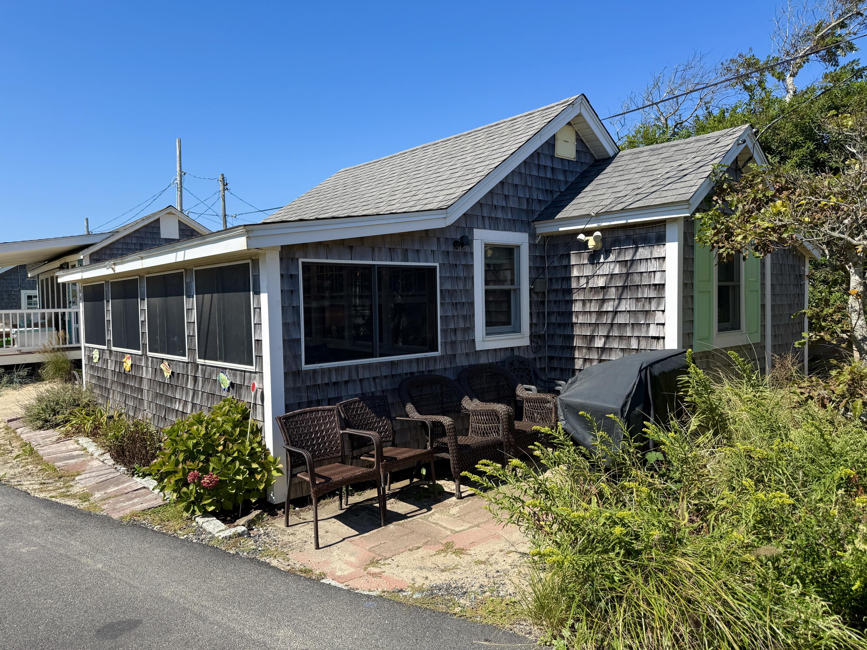 217 Old Wharf Road, Unit 64 Dennis Port, MA 02639 - Photo 4 of 25 a view of house with chair and tables