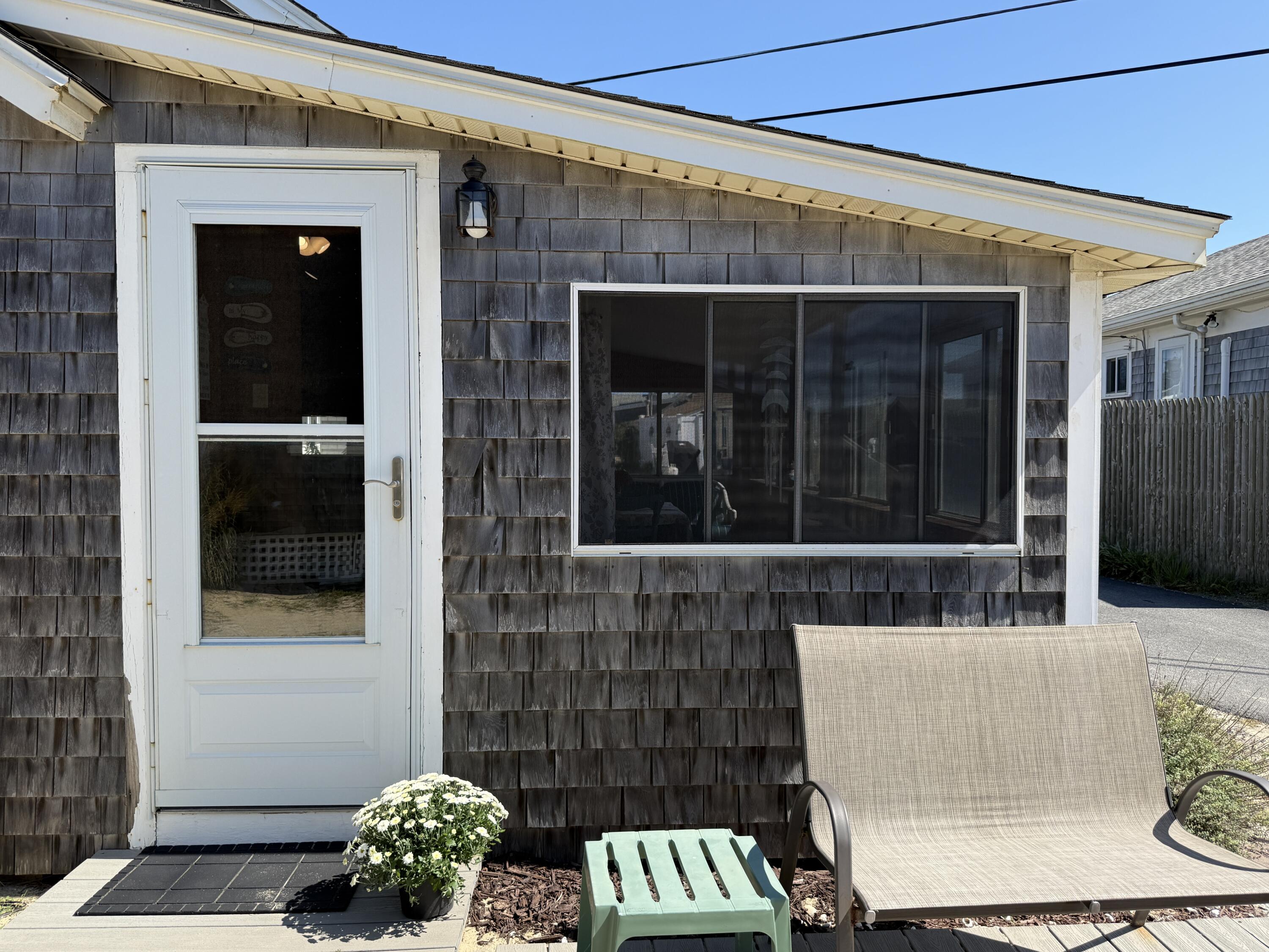 217 Old Wharf Road, Unit 64 Dennis Port, MA 02639 - Photo 5 of 25 a view of a door with a bench in front of house
