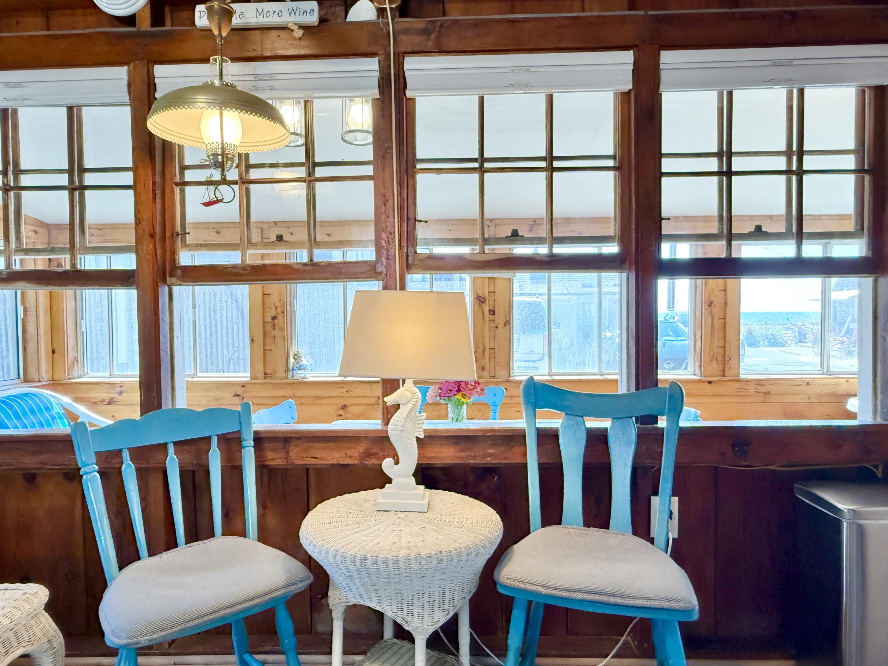 217 Old Wharf Road, Unit 64 Dennis Port, MA 02639 - Photo 9 of 25 a view of a dining room with furniture large windows and wooden floor