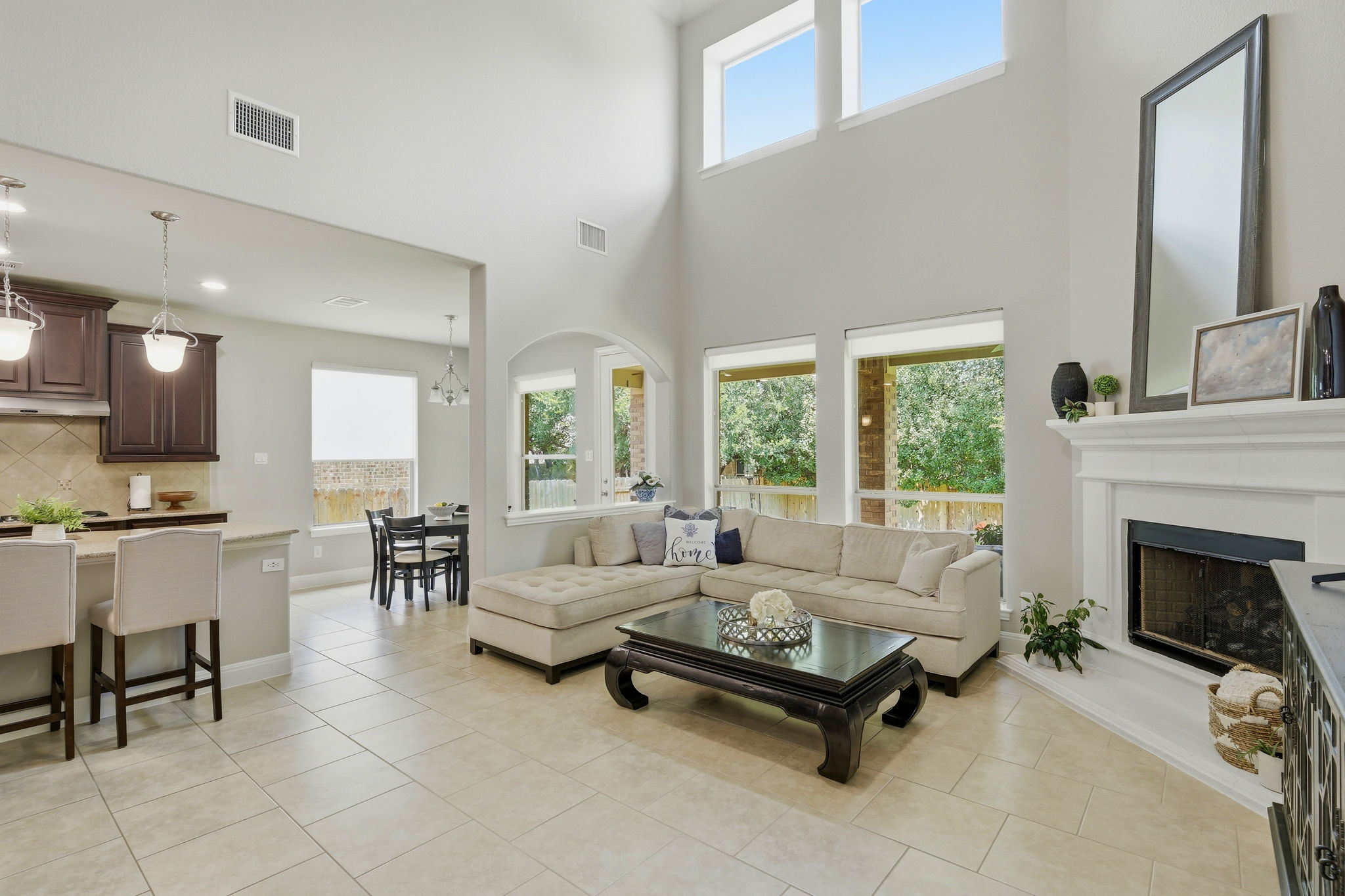 110 Dasher Drive Cedar Park, TX 78613 - Photo 8 of 39 Natural light floods this living area, showcasing its soaring ceilings and elegant fireplace.