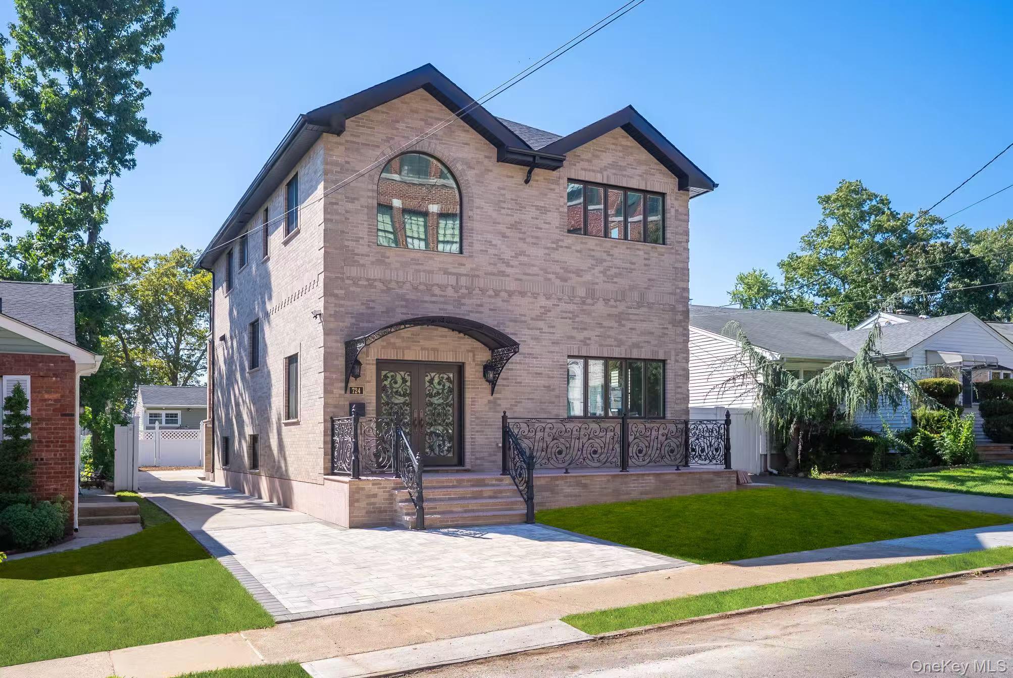 View of front of house with brick siding, french doors, and a front lawn