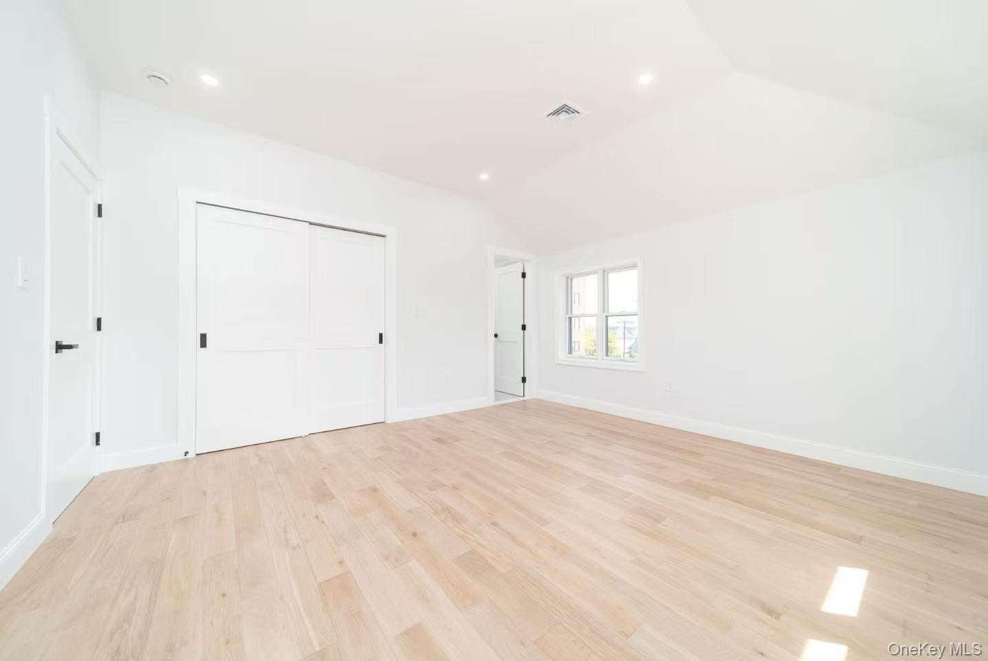 7-24 128th Street Queens, NY 11356 - Photo 16 of 31 Unfurnished bedroom with light wood-type flooring, recessed lighting, a closet, and vaulted ceiling