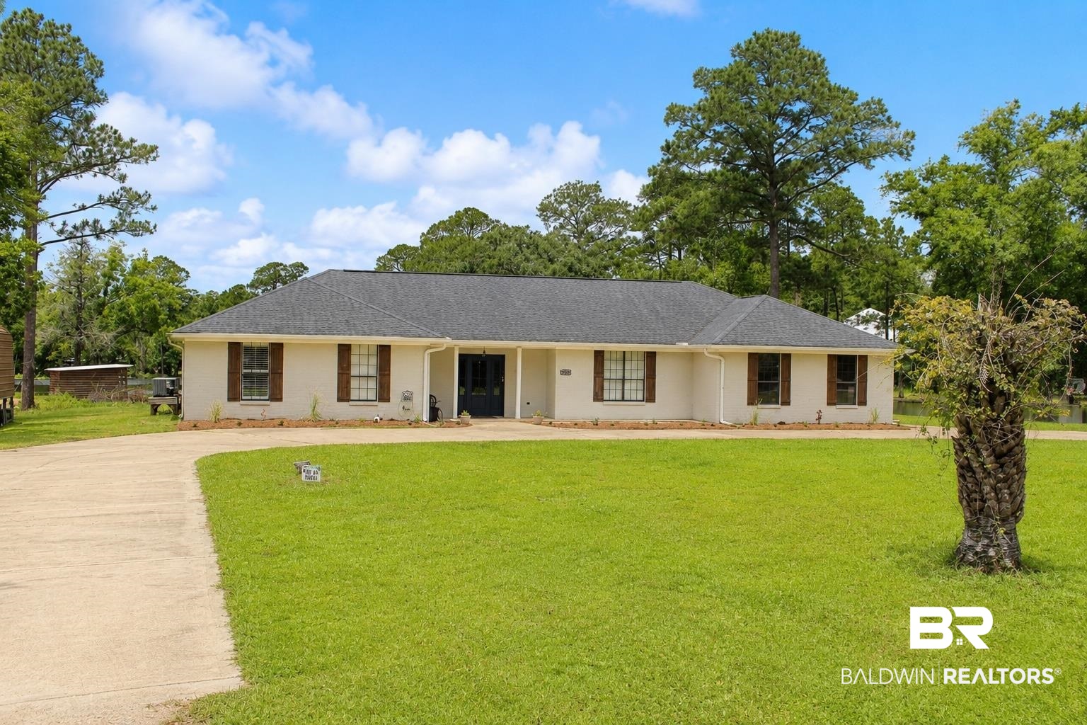 9825 Wolf Creek Ridge Elberta, AL 36530 - Photo 3 of 76 Ranch-style residence featuring a dark shingle roof, light-colored stucco exterior, and decorative wooden shutters
