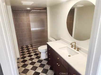 a bathroom with a sink a toilet a shower and a mirror