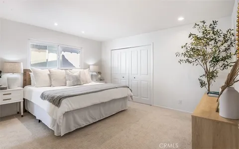 a bedroom with a bed and a potted plant