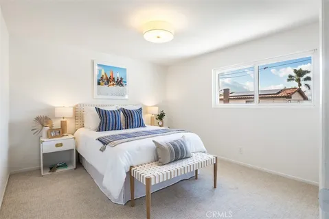 a bedroom with a bed and a painting on the wall