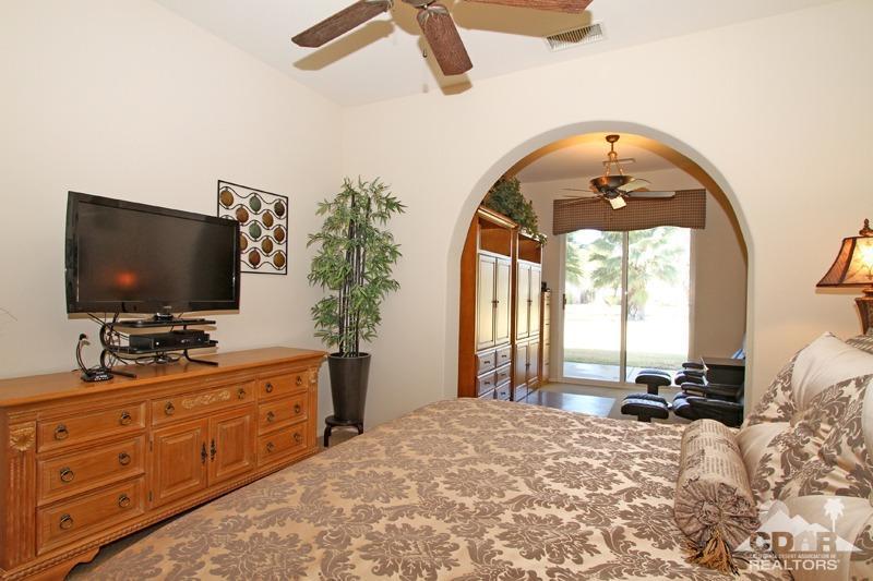 7 Wimbledon Circle Rancho Mirage, CA 92270 - Photo 20 of 46 a bedroom with a bed and a flat tv screen on dresser