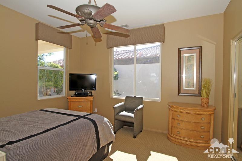 7 Wimbledon Circle Rancho Mirage, CA 92270 - Photo 27 of 46 a bedroom with a bed and a chandelier
