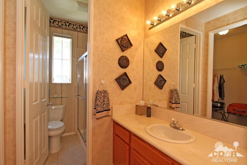 7 Wimbledon Circle Rancho Mirage, CA 92270 - Photo 28 of 46 a bathroom with a granite countertop sink a toilet and shower