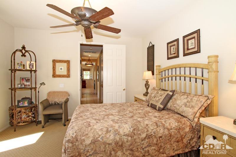 7 Wimbledon Circle Rancho Mirage, CA 92270 - Photo 30 of 46 a bedroom with a bed and a chandelier