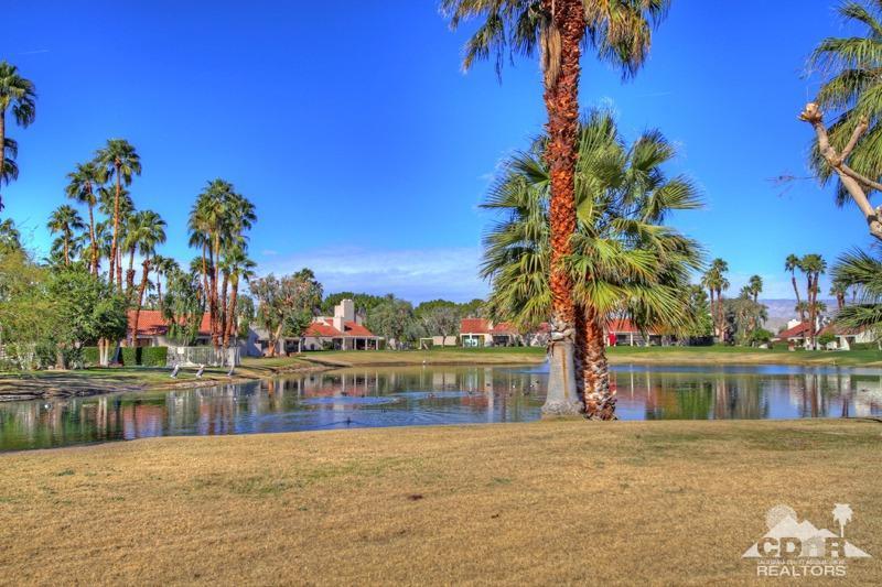 7 Wimbledon Circle Rancho Mirage, CA 92270 - Photo 35 of 46 a front view of a house with a garden and lake view