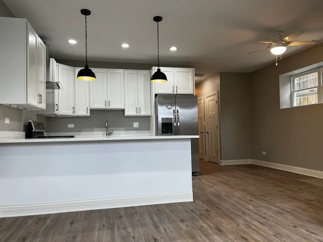 a kitchen with kitchen island a counter space a sink appliances and cabinets