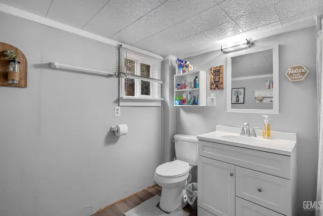 a bathroom with a toilet sink vanity and mirror