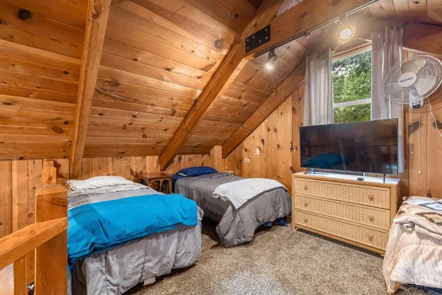 a bedroom with two beds and a flat screen tv