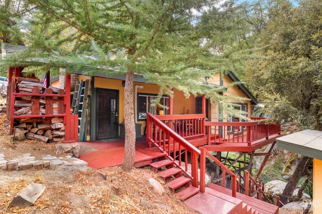 a view of a house with large trees and furniture