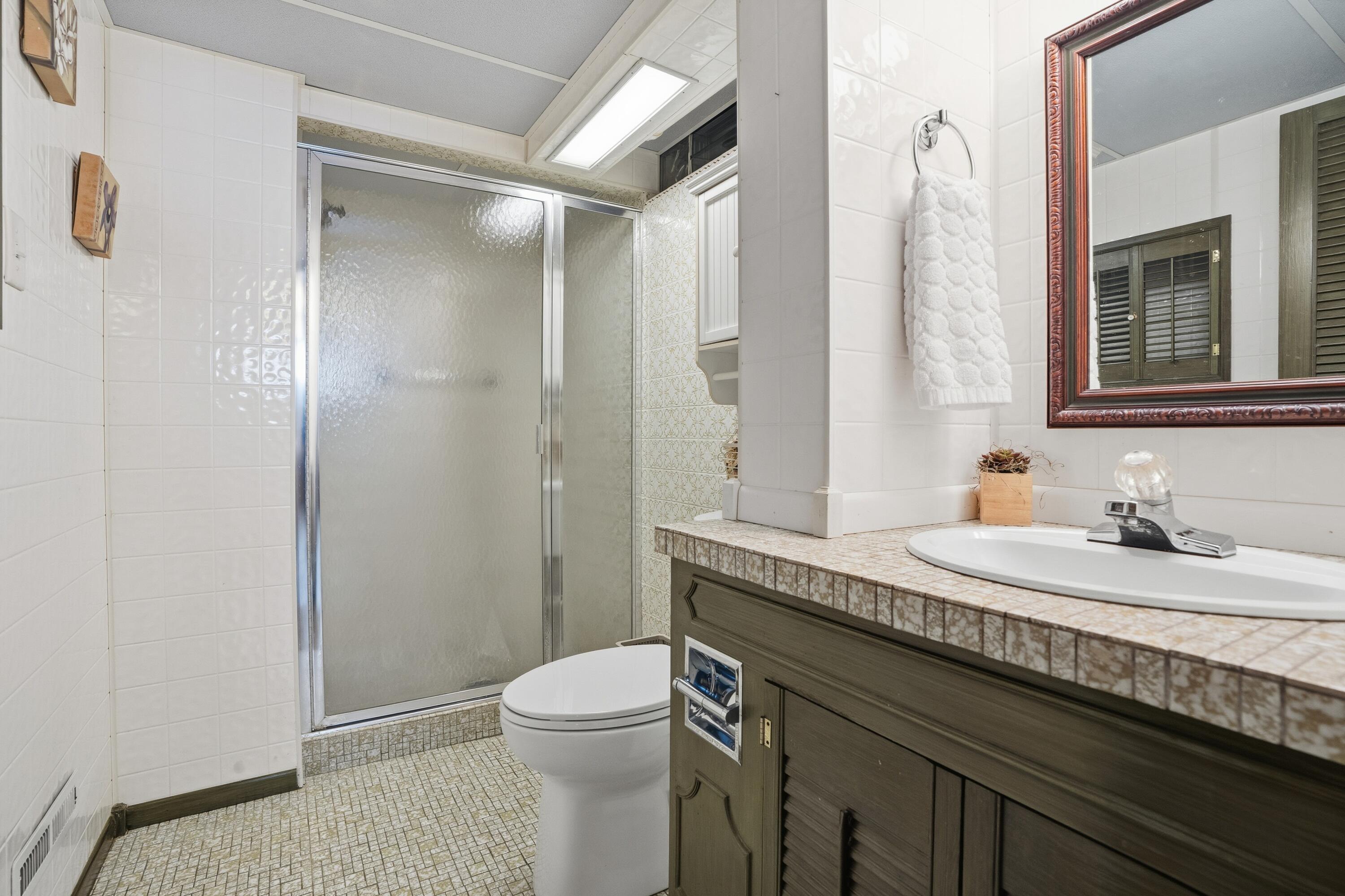 3514 41st Place Highland, IN 46322 - Photo 19 of 26 a bathroom with a granite countertop sink a toilet and a mirror