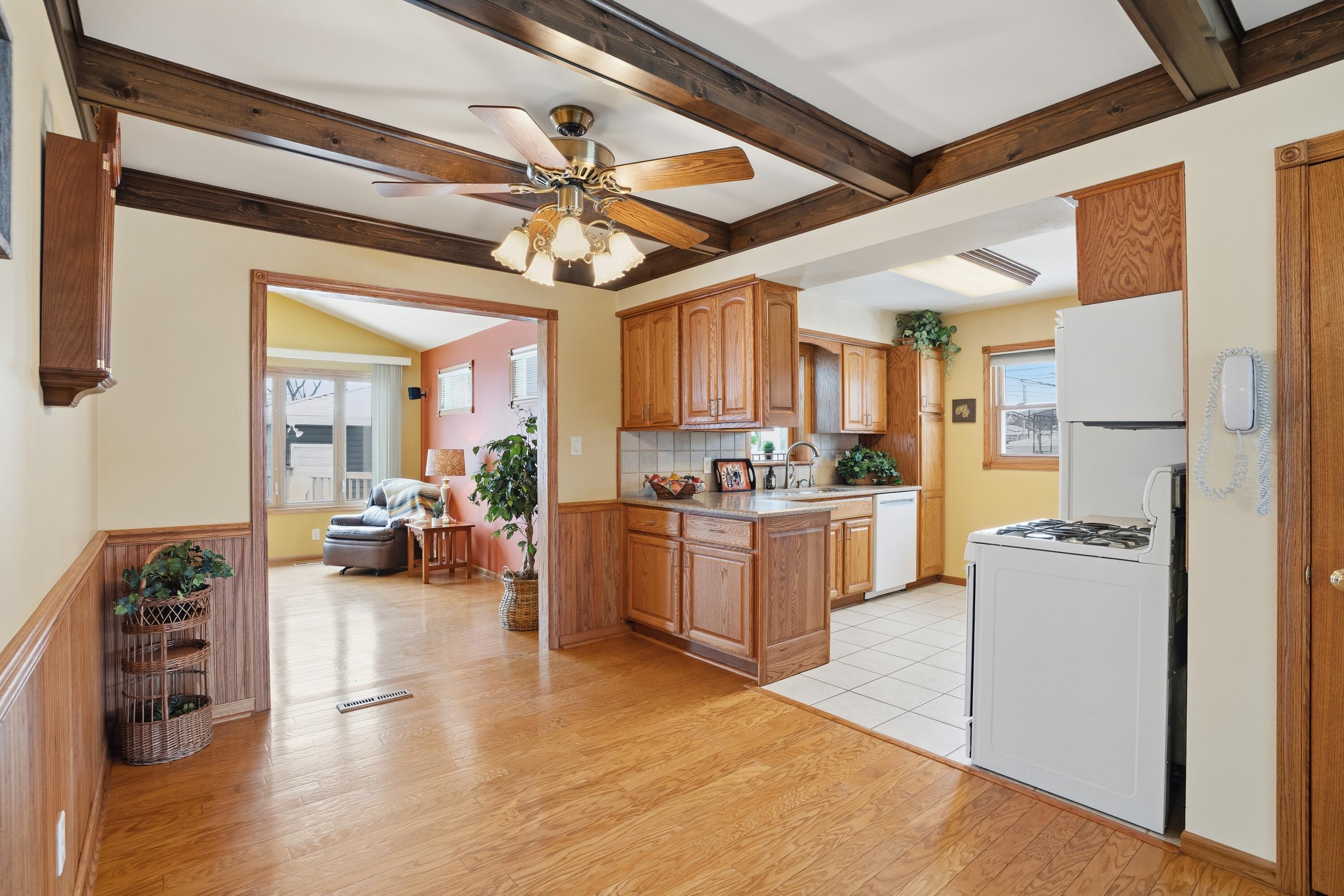 3514 41st Place Highland, IN 46322 - Photo 9 of 26 a open kitchen with a refrigerator a stove top oven a chimney cabinets and wooden floor