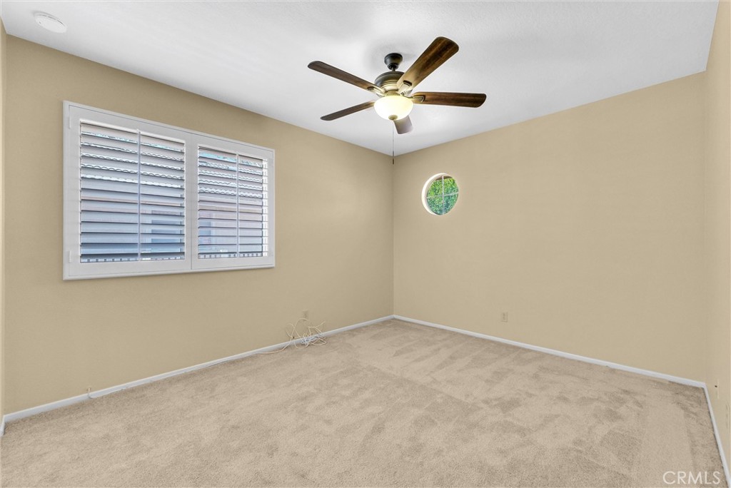 17358 Cold Spring Circle Riverside, CA 92503 - Photo 21 of 34 an empty room with a window and a ceiling fan
