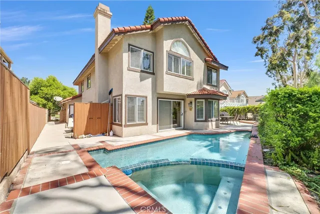 a view of a house with pool and sitting area