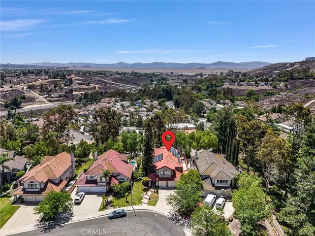 an aerial view of a houses with a street and green space