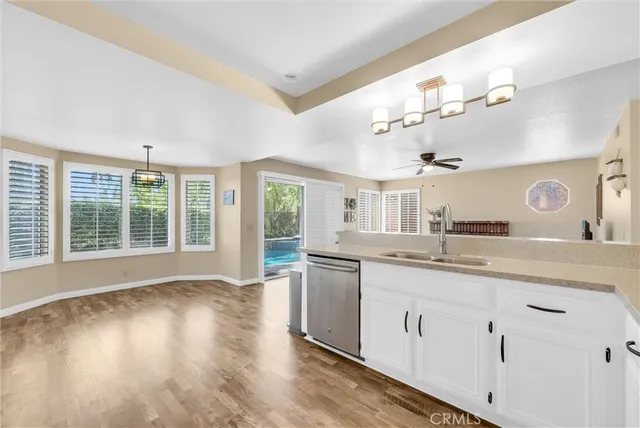 a large white kitchen with kitchen island a sink a stove and a large window