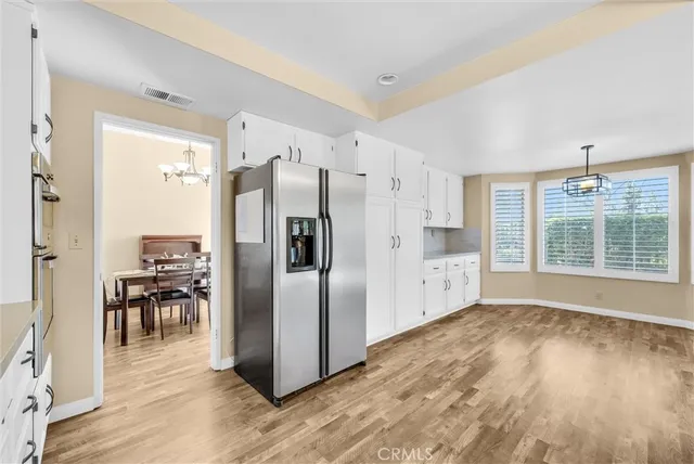 a kitchen with stainless steel appliances a refrigerator and wooden floor