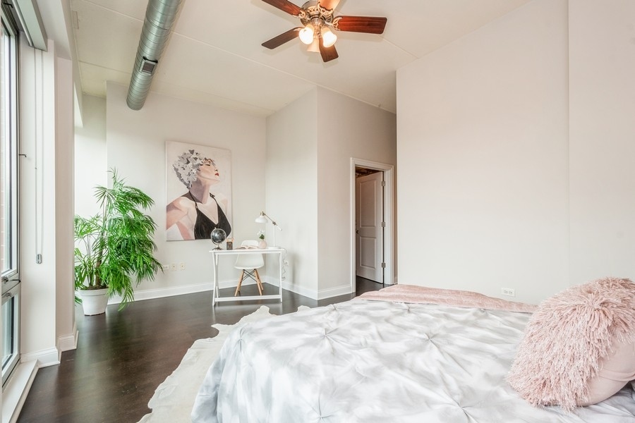 4814 North Clark Street, Unit 201 Chicago, IL 60640 - Photo 14 of 24 a bedroom with a bed and a chandelier