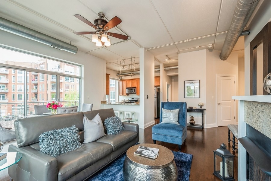 4814 North Clark Street, Unit 201 Chicago, IL 60640 - Photo 5 of 24 a living room with furniture a fireplace and a chandelier