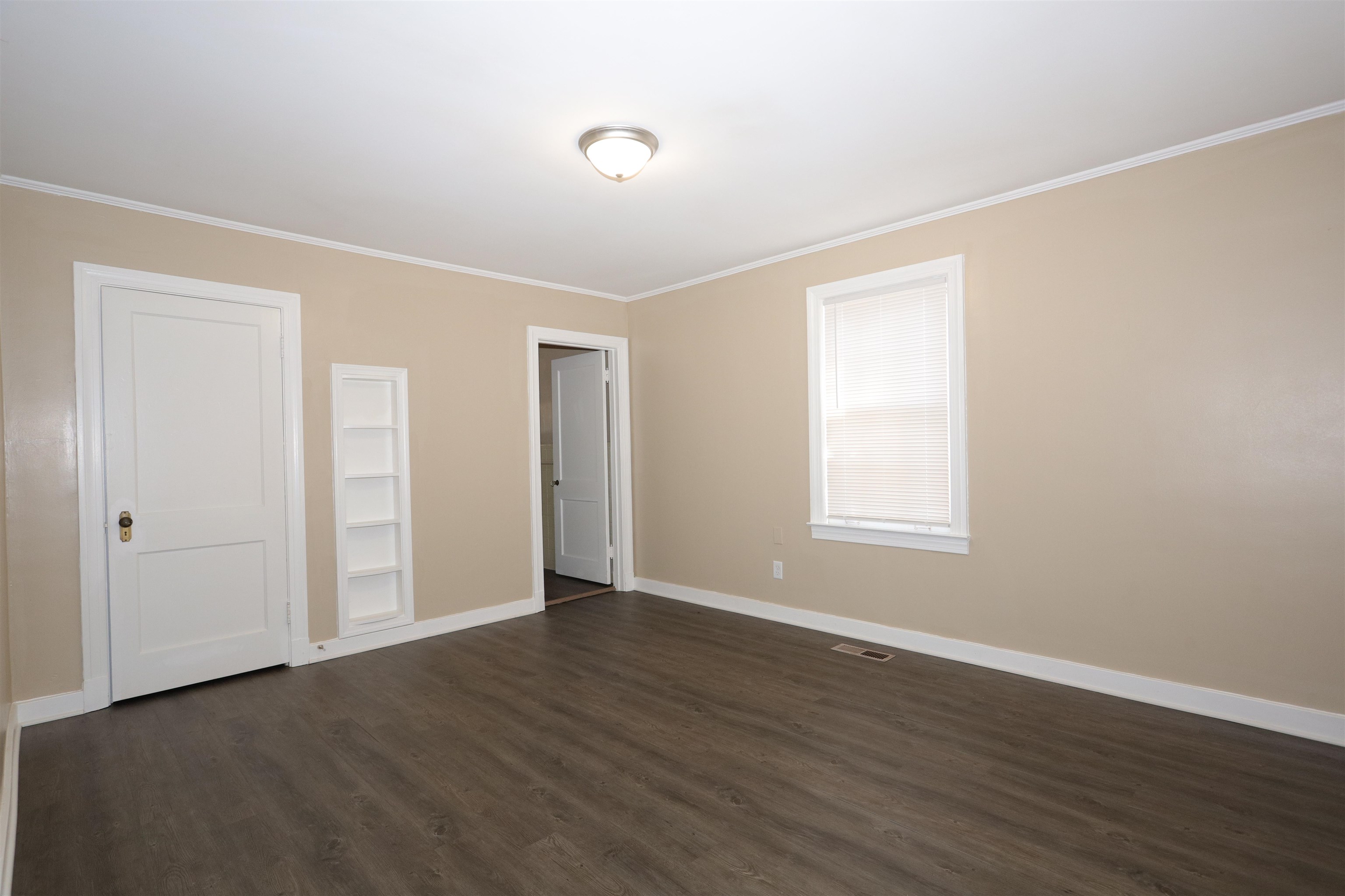1042 Mosby Road Memphis, TN 38116 - Photo 19 of 21 a view of an empty room with wooden floor and a window