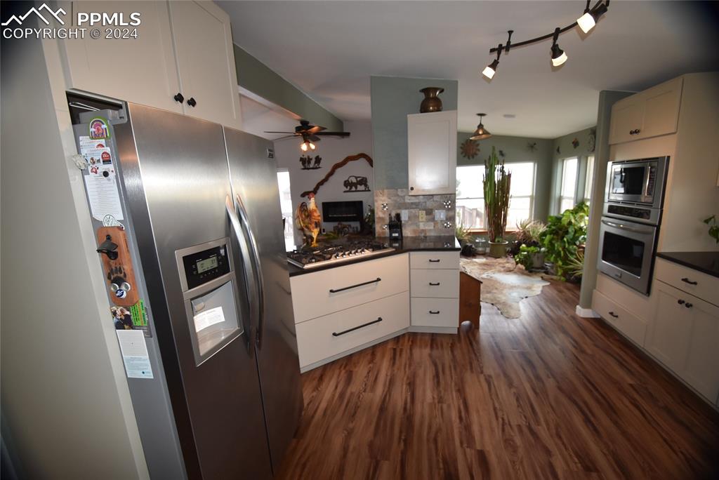 9990 Hahn Road Calhan, CO 80808 - Photo 4 of 25 a kitchen with stainless steel appliances a refrigerator sink and wooden floor