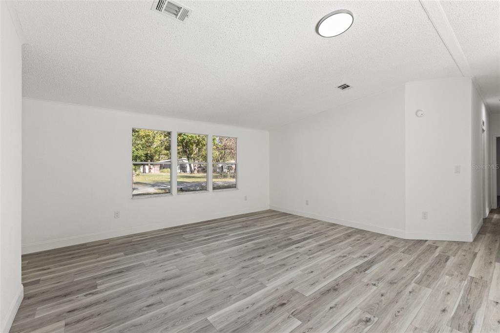 6718 West Pershing Drive Homosassa, FL 34448 - Photo 18 of 47 an empty room with wooden floor and windows