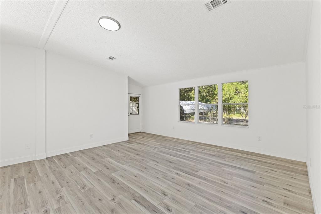 6718 West Pershing Drive Homosassa, FL 34448 - Photo 20 of 47 an empty room with wooden floor and windows