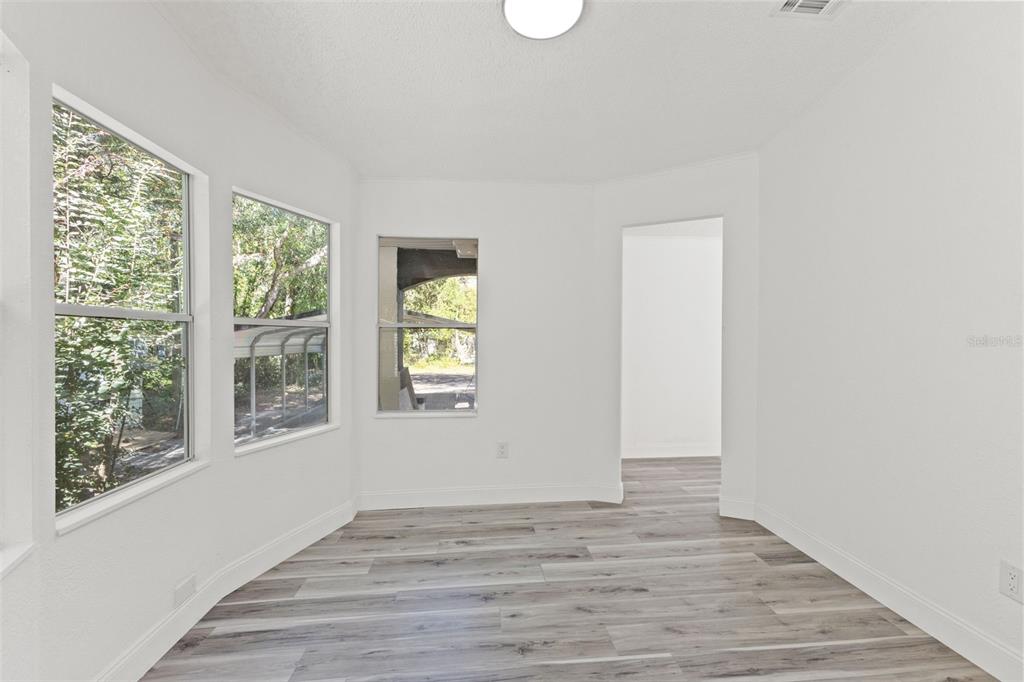 6718 West Pershing Drive Homosassa, FL 34448 - Photo 6 of 47 a view of an empty room with wooden floor and a window
