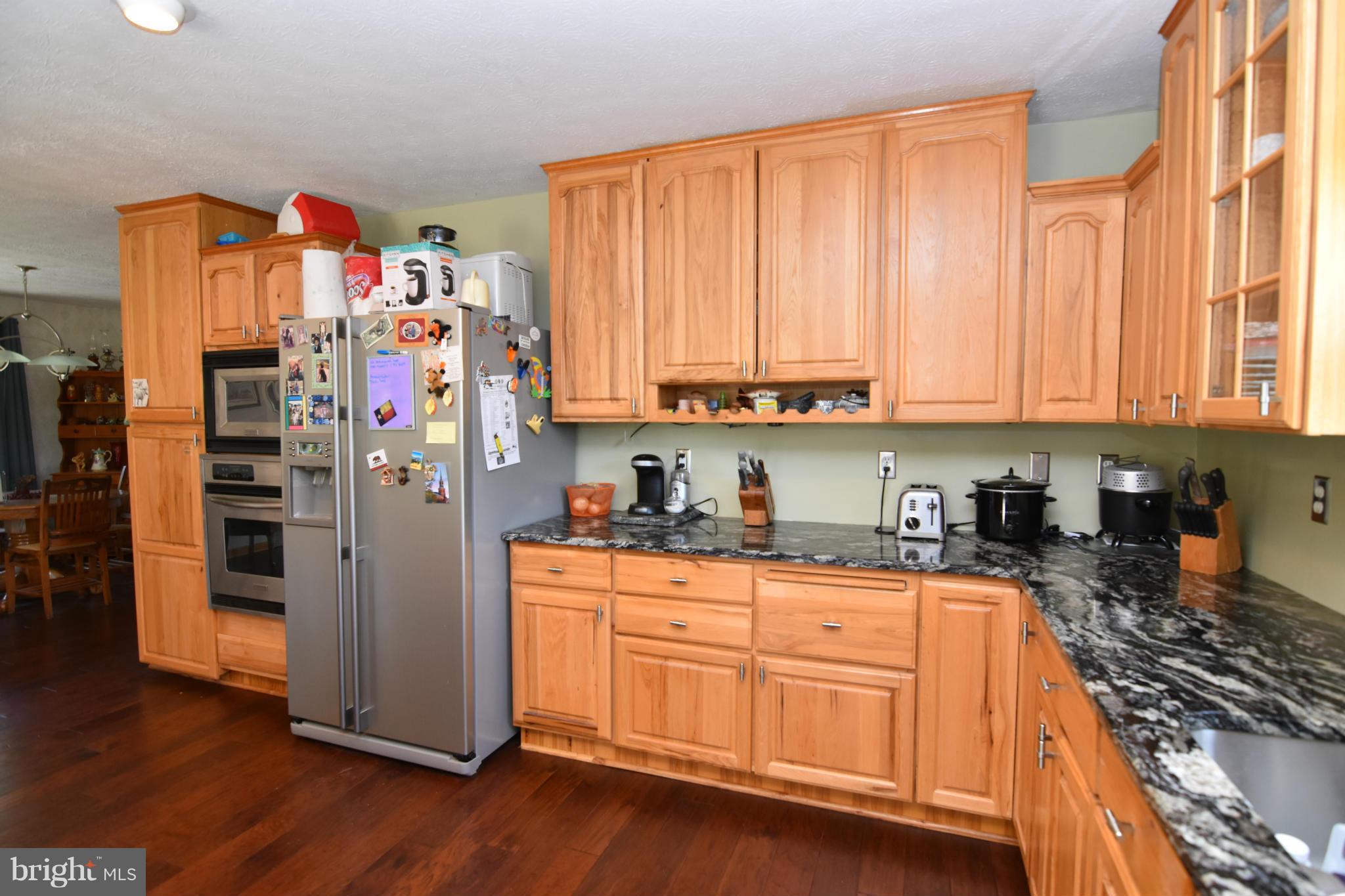 20510 Raceground Road Callaway, MD 20620 - Photo 5 of 30 a kitchen with stainless steel appliances granite countertop a refrigerator and wooden cabinets