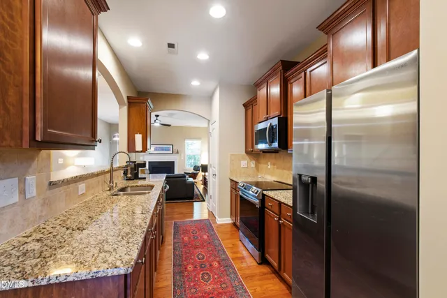 a large kitchen with stainless steel appliances granite countertop a large stove top oven a refrigerator and dishwasher