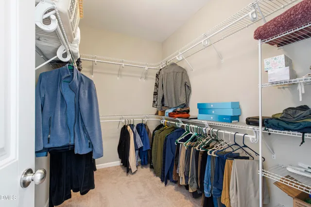 a view of walk in closet with clothes and shoes