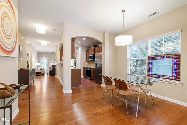 a view of a dining room and livingroom with furniture wooden floor a chandelier